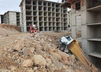 Bina boşluğuna devrilen kamyonu vinç çıkardı