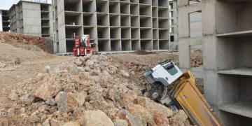 Bina boşluğuna devrilen kamyonu vinç çıkardı