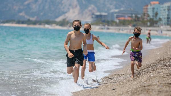 Antalya'da tatilciler maskeyle güneşlendi