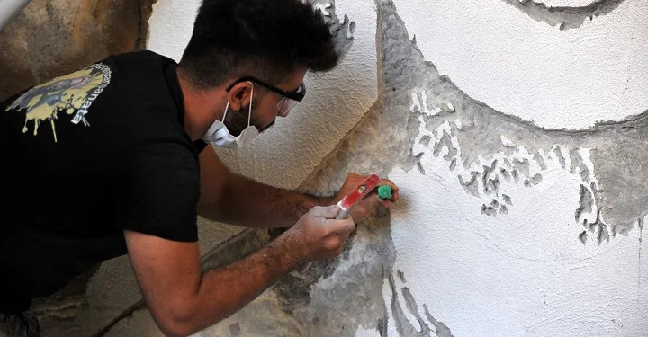 Boyayla değil, duvarı kırarak resim yapıyorlar