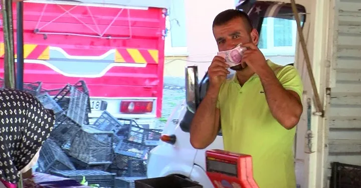 Görüntülendiğini fark etti, parayı maske olarak kullandı