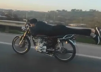 Kasksız sürücü motosikleti yatarak kullandı