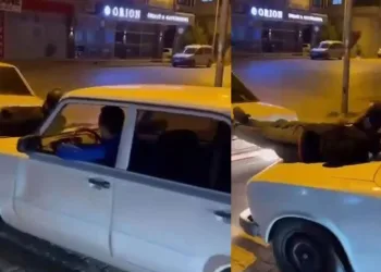 İki otomobilin arasına uzanıp, aracı ayaklarıyla itti