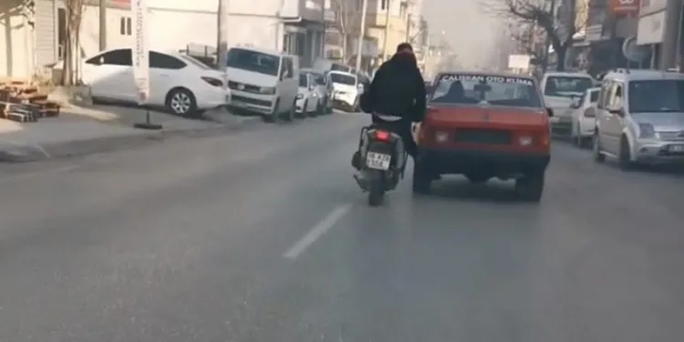 Bursa’da bozulan otomobili motosiklet ile itti
