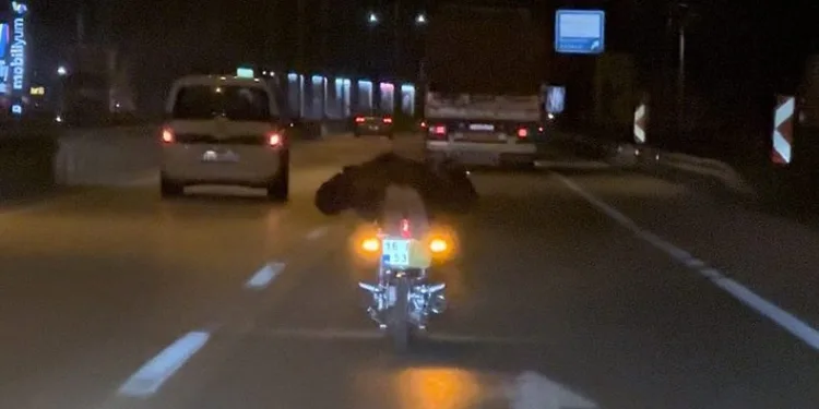 Motosikleti yatarak kullandı