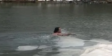 Buz tutmuş göle girerek yüzdü