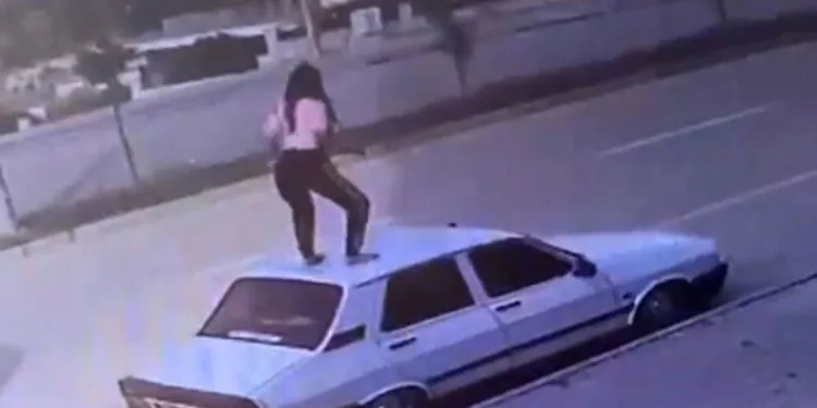 Otomobilin tavanına çıkıp dans etti