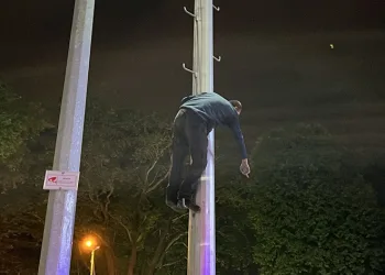 Kaçan dilenci aydınlatma direğine çıktı