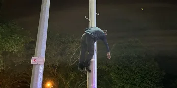 Kaçan dilenci aydınlatma direğine çıktı