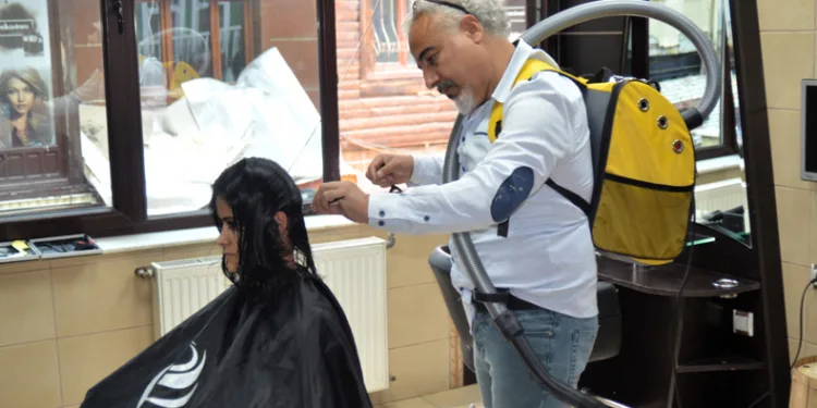 Elektrikli süpürge ile saç kesimi yapıyor