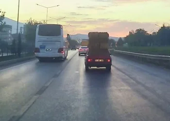 Trafikte otomobil üzerinde saman balyaları taşıdı