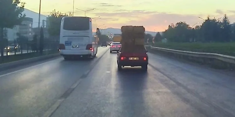 Trafikte otomobil üzerinde saman balyaları taşıdı