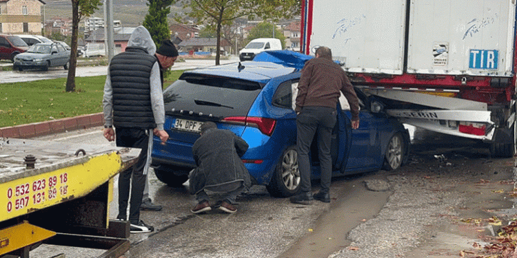 Otomobil park halindeki tırın altına girdi