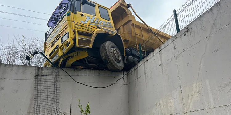 Hafriyat kamyonu istinat duvarında askıda kaldı