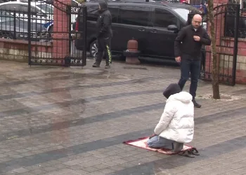 Yağmura rağmen namazına devam etti