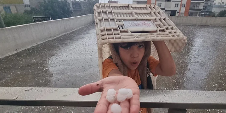 Dolu yağışında küçük çocuk plastik kasa altında eğlendi