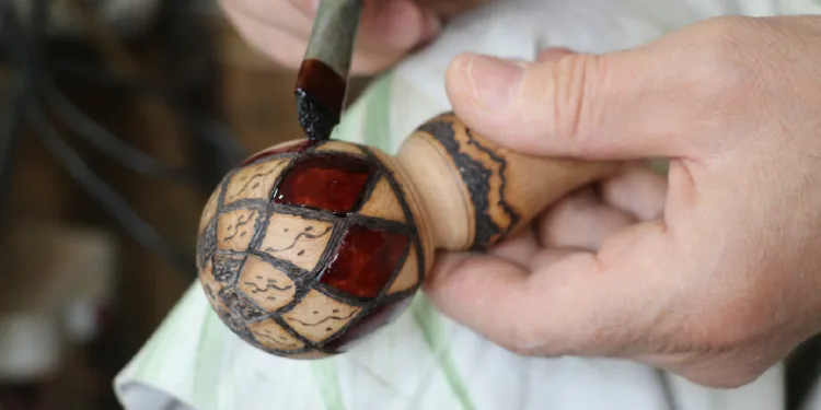 Kilim motiflerini bastona işliyor
