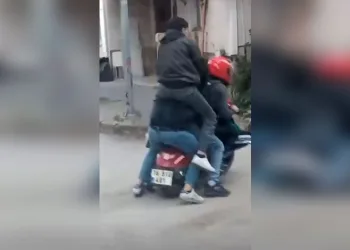 Motosiklete sığmak için sürücünün omzuna çıkmıştı: Ceza kesildi