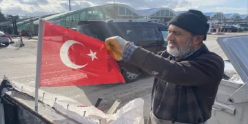 Çöpe Atılan Bayrakları Bisikletinde Dalgalandırıyor