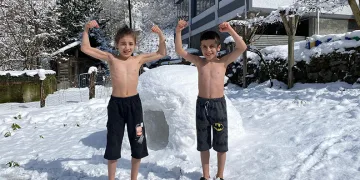 Kardeşlerin kar üzerinde güreş antrenmanı
