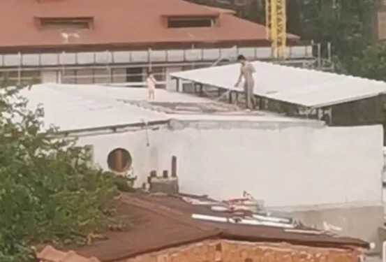 Çocukla birlikte çatıda halı yıkayan vatandaş kamerada