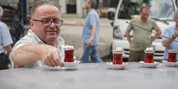 Çay ocağından aldığı çayları otomobiliyle taşıyor