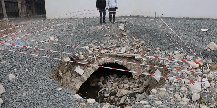 Depremde yıkılan binanın arazisinde yaşanan göçükle tarihi su kanalı ortaya çıktı
