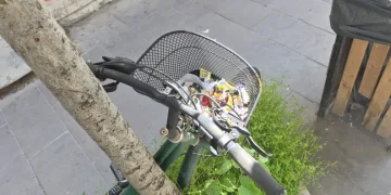 Çöp kutusunun hemen yanındaki bisikletin sepeti atıklarla doldu
