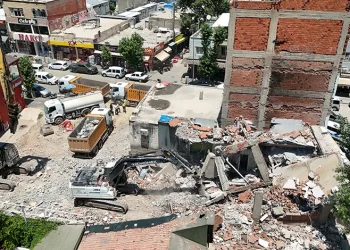 Yıkılan binanın parçaları iş yerinin üzerine düştü