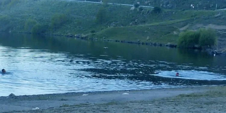 Sıcaktan bunalan gençler Çıldır Gölü’nde serinliyor